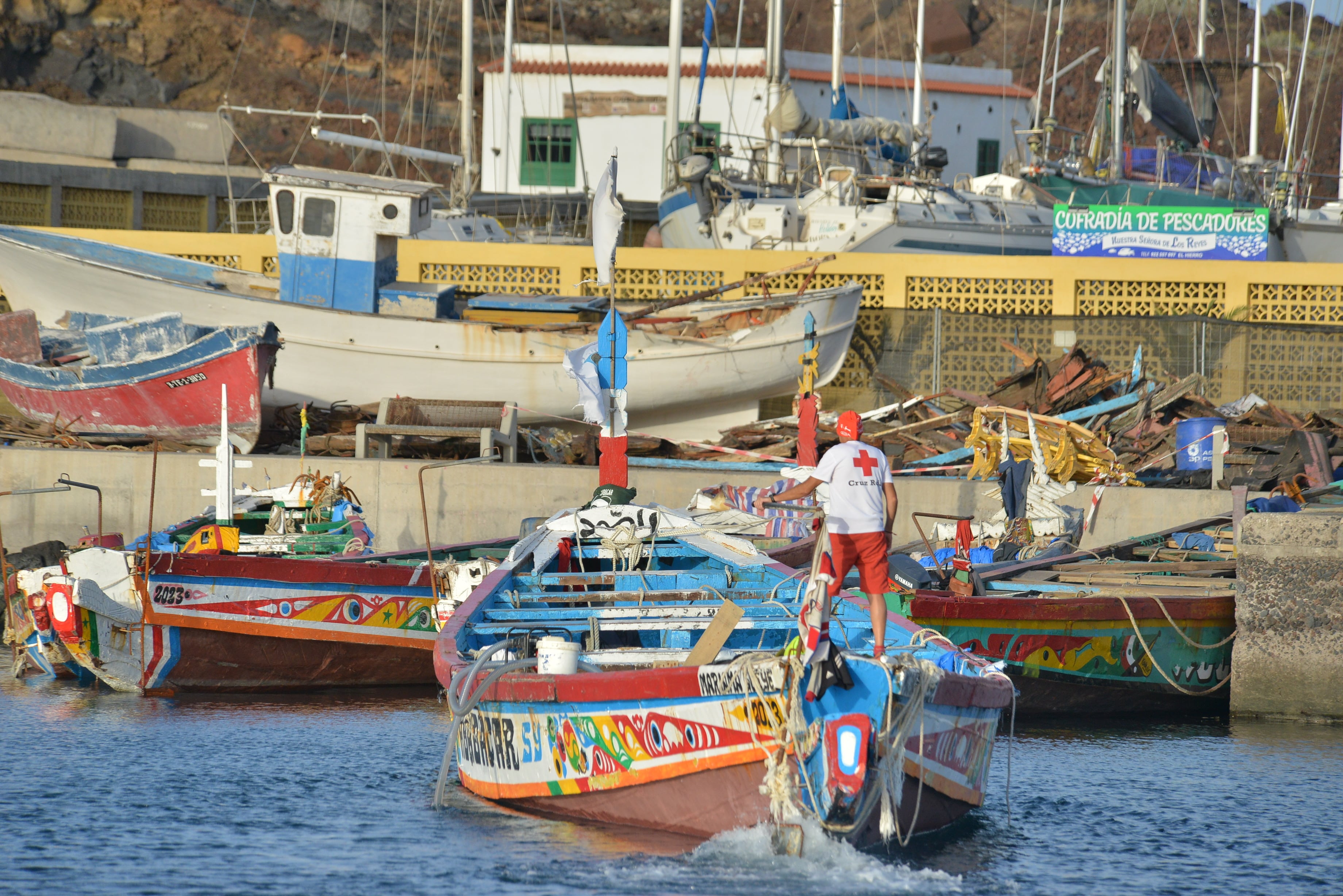 EL PINAR (EL HIERRO), 05/10/2023.- Un voluntario de Cruz Roja colabora junto a la policía portuaria en el atraque de los cayucos que se amontonan en el puerto de La Restinga en el municipio de El Pinar, tras la llegada masiva de migrantes durante los últimos días a El Hierro. EFE/ Gelmert Finol
