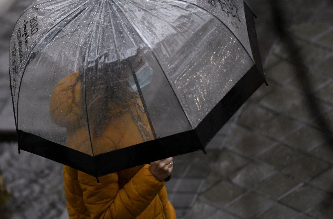 Una persona camina bajo la lluvia 