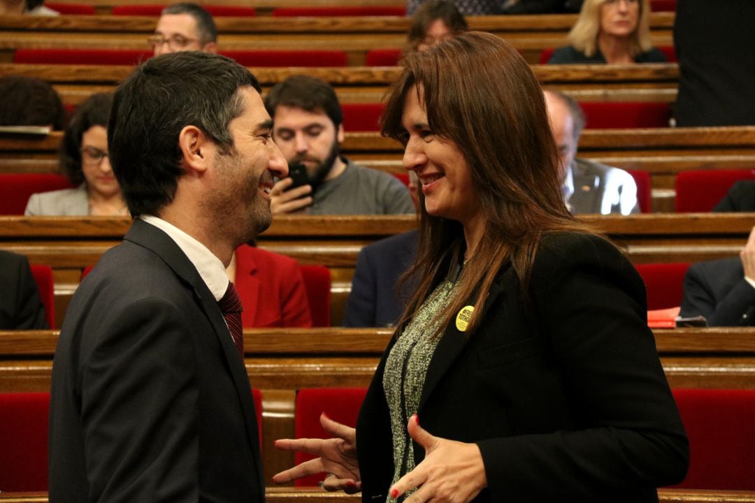 Jordi Puigneró conversa con Laura Borràs en el Parlament de Cataluña.