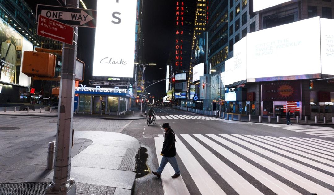 Varias personas caminan por una silenciosa y casi desierta Times Square en Nueva York. 