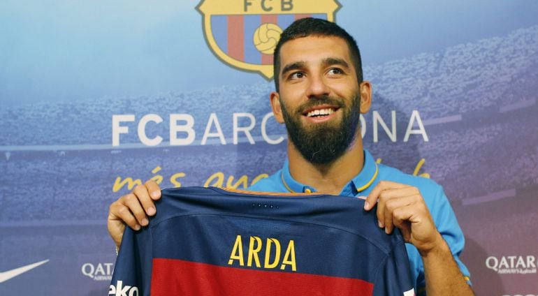 El centrocampista turco Arda Turan posa con su camiseta durante la rueda de prensa en la que ha sido presentado como nuevo jugador del Barcelona para las próximas cinco temporadas.