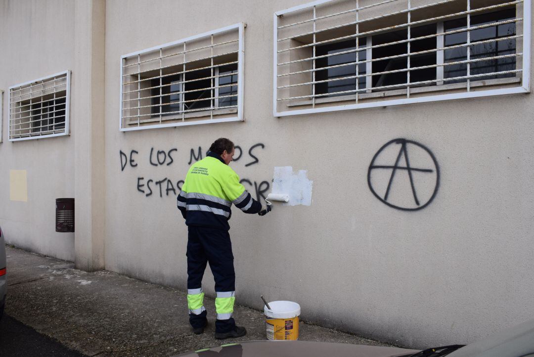 Un operario de Urbaser elimina una de las polémicas pintadas