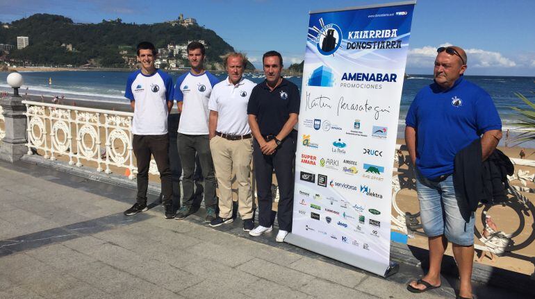 Alberto López y Mendizabal posan junto a dos remeros con la Playa de la Concha al fondo