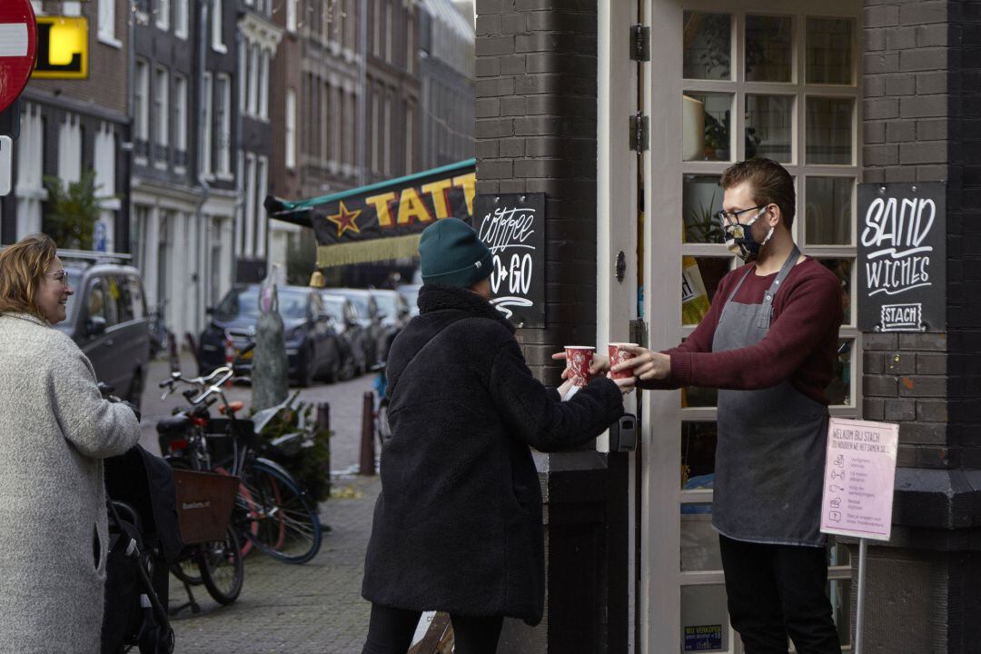 Un barista sirve un café en una calle de Amsterdam.  