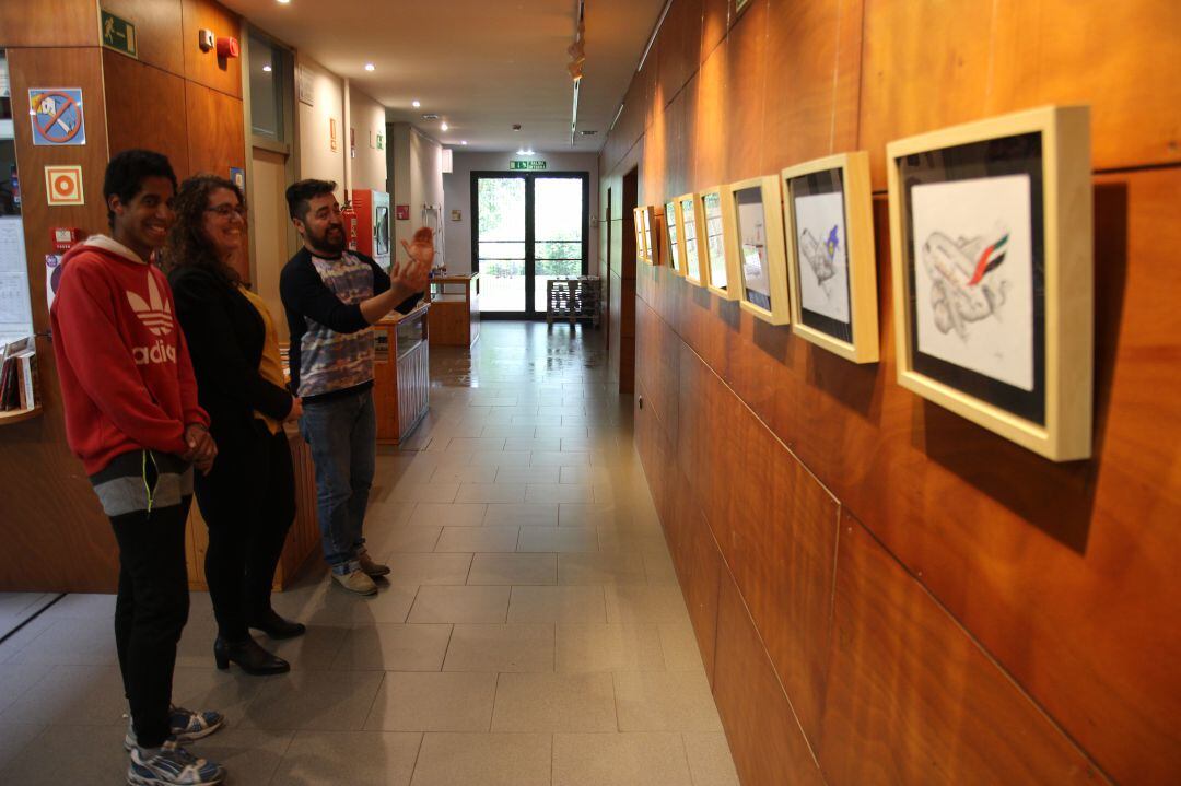 El joven artista Josu González, observa su obra colgada en el Gazteleku, junto a la delegada Mónica Martínez y Garikoitz Murua, coordinador del programa Gazteartean Expo.