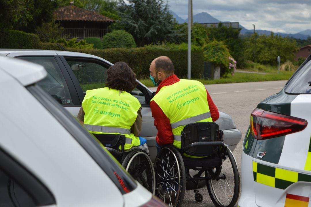 Los voluntarios de ASPAYM informan a los conductores en uno de los controles montados por la Guardia Civil en Asturias