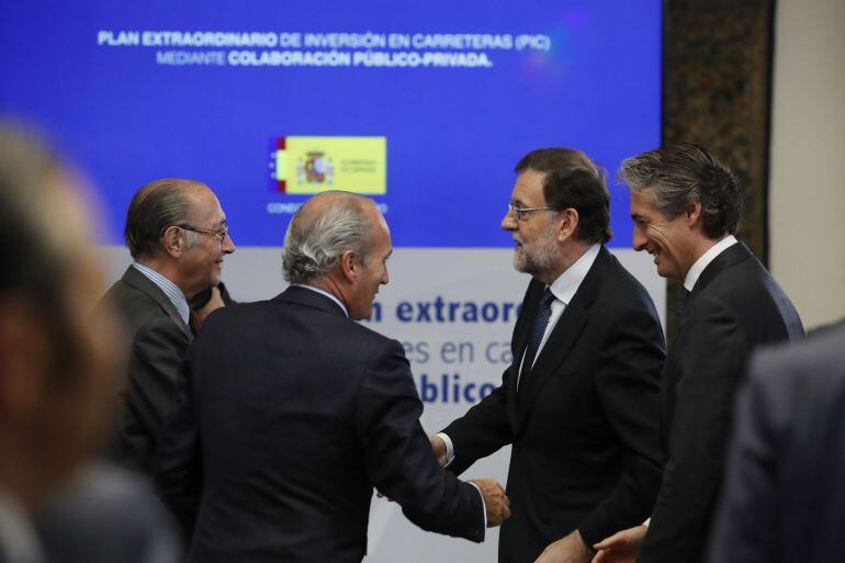 El presidente del Gobierno, Mariano Rajoy (2d), y el ministro de Fomento, Íñigo de la Serna (d), a su llegada a la presentación del Plan Extraordinario de Inversiones en Carreteras.