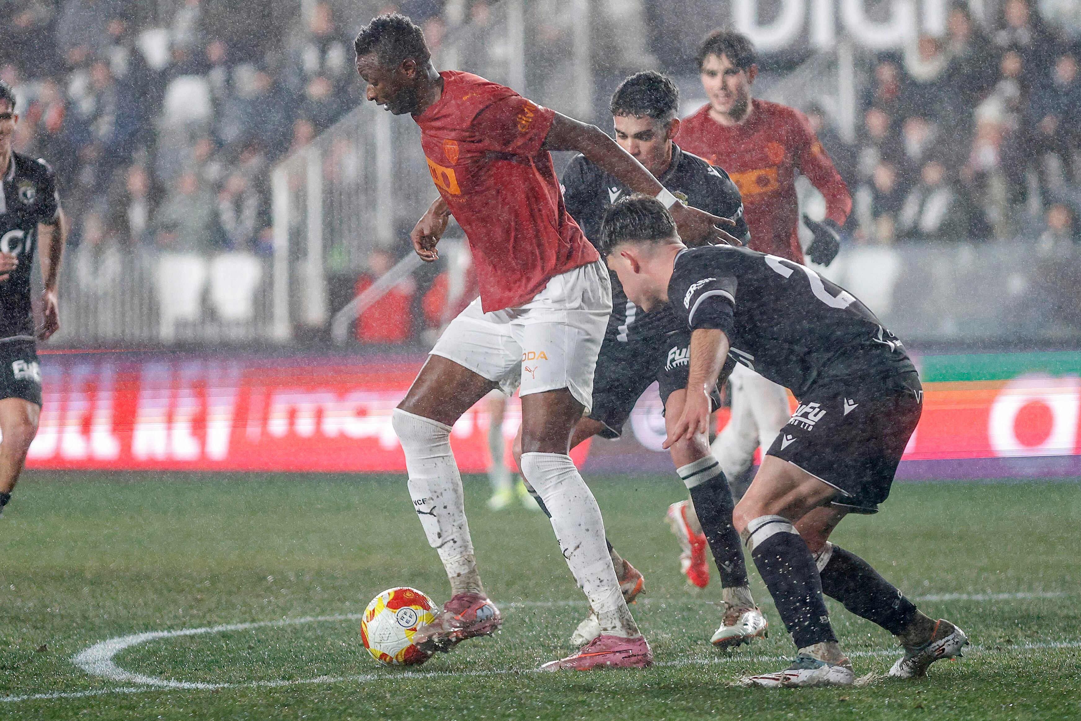 BURGOS, 15/01/2026.- El delantero del Valencia Sadiq Umar (i) controla el balón junto a Brais Martínez, del Burgos, durante el partido de octavos de final de Copa del Rey que Burgos CF y Valencia CF disputan este jueves en el estadio de El Plantío, en Burgos. EFE/Santi Otero