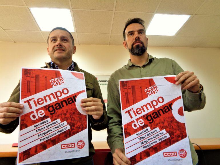 Javier Fernández Lanero (UGT) y José Manuel Zapico (CCOO) muestran el cartel del Primero de Mayo, cuya manifestación este año se celebrará en Langreo