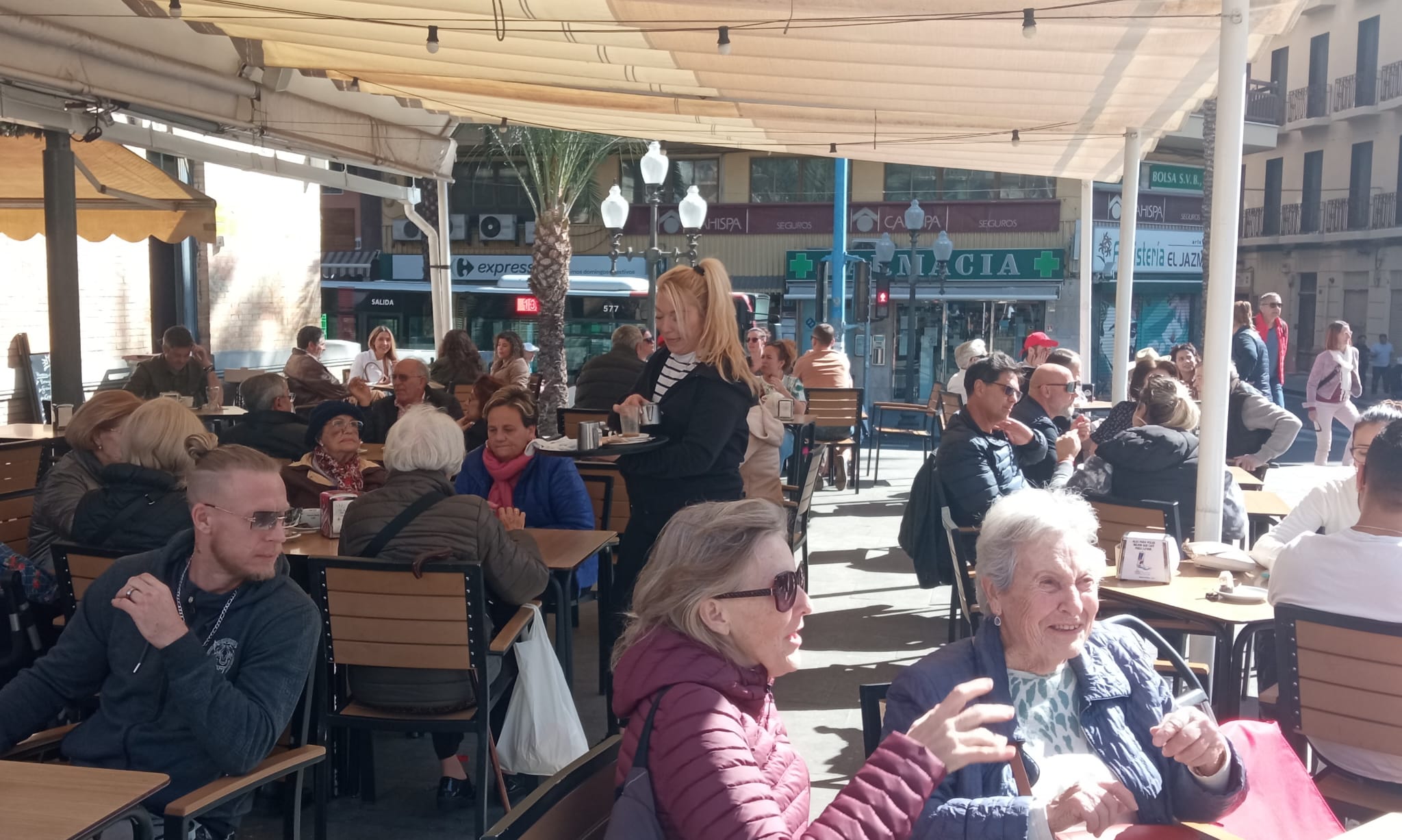 Una camarera atiende a unas clientas en una cafetería de la plaza 25 de mayo de Alicante (archivo)