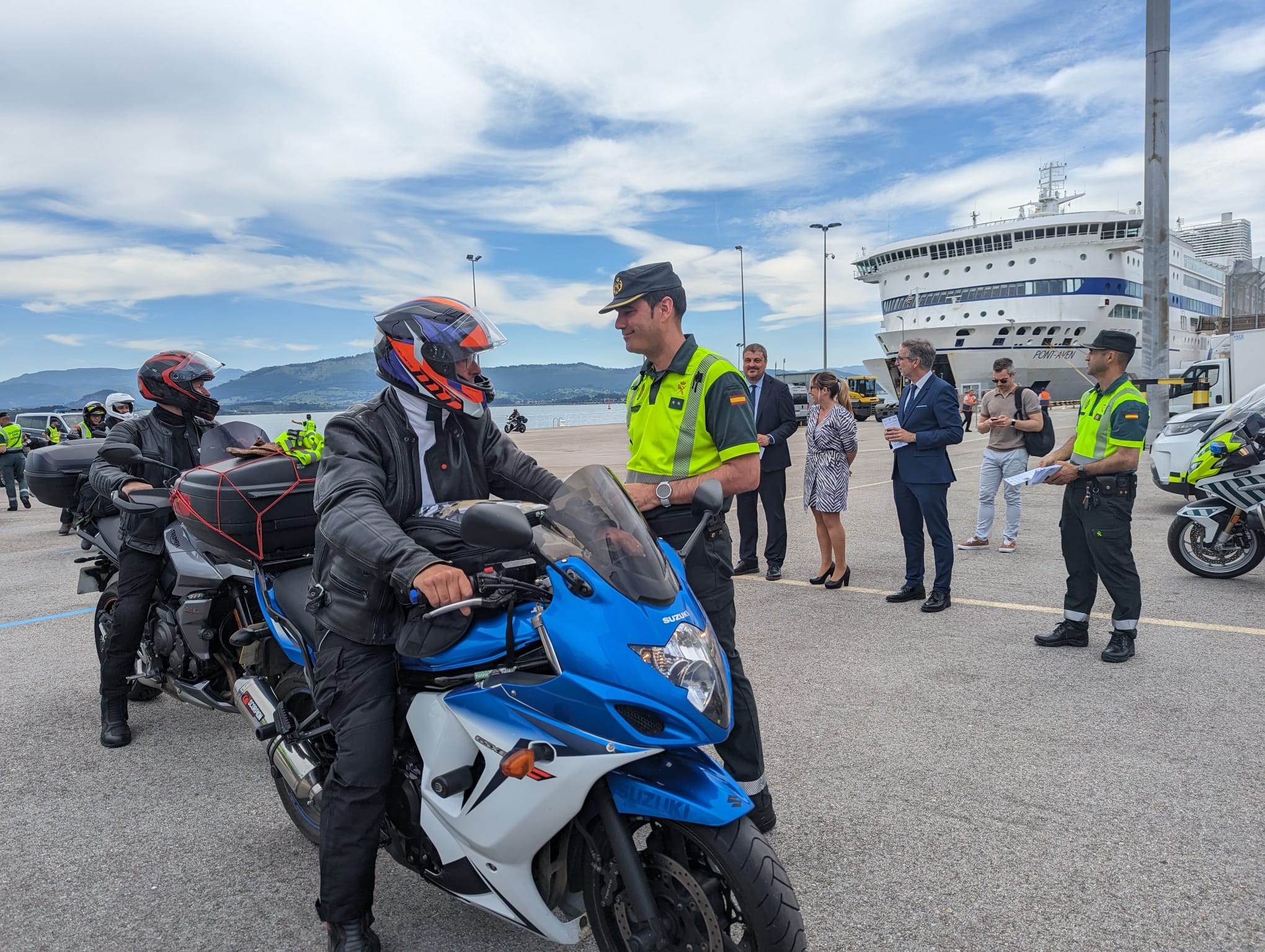 Agente de la Guardia Civil entregando tríptico informativo a conductores de motos procedentes de Gran Bretaña