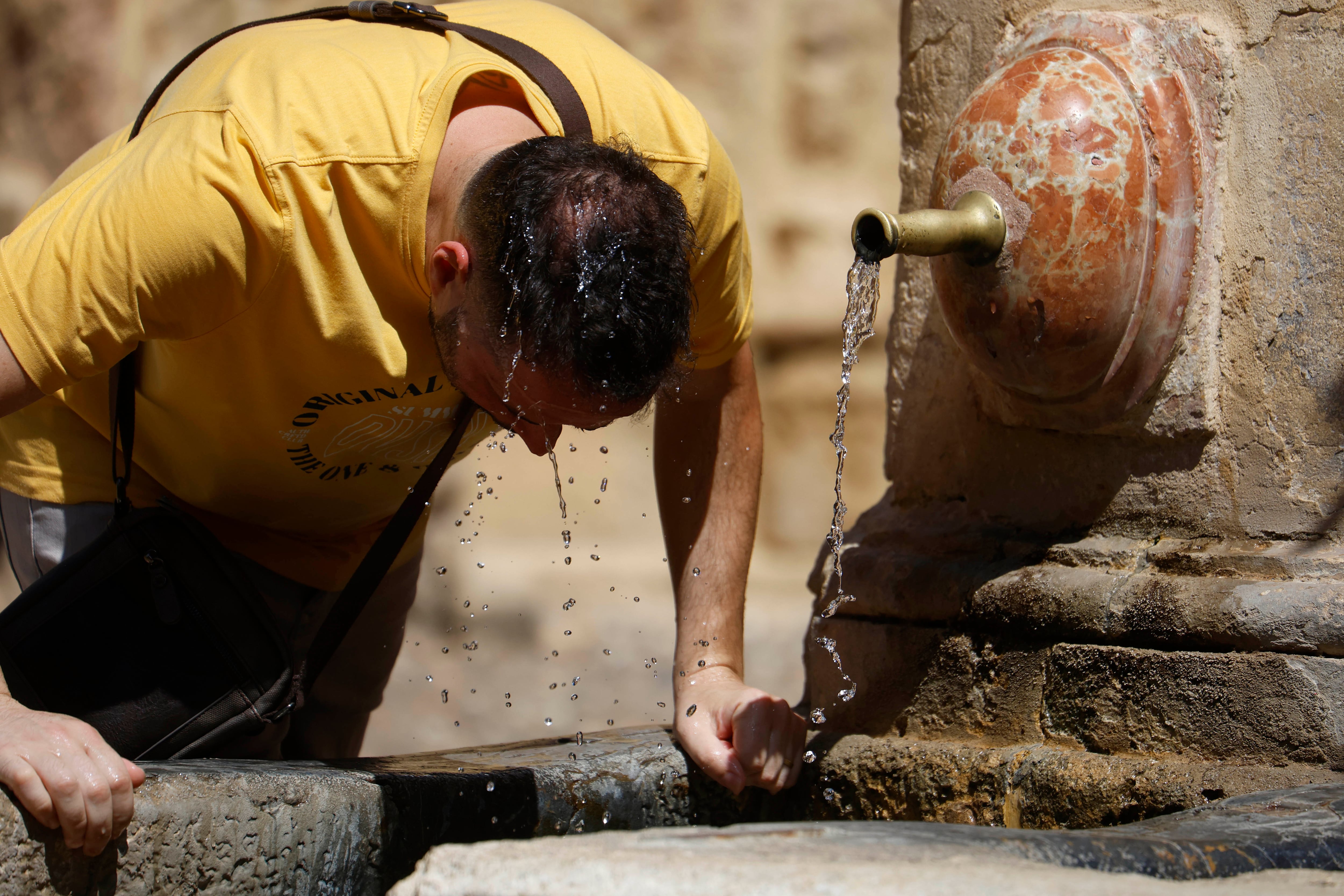 GRAFAND2887. CÓRDOBA, 09/08/2024.- Un hombre se refresca con agua de una fuente de Córdoba, este viernes en el que arranca una nueva ola de calor que podría ser la más intensa del verano hasta ahora, con máximas muy por encima de la media y temperaturas que tenderán a aumentar. EFE/Salas
