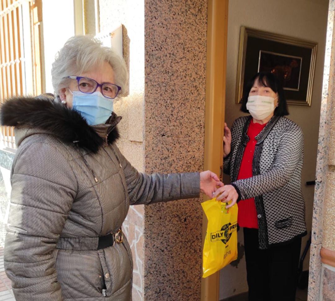 Una voluntaria lleva recados a casa a una mujer de Huétor Tájar (Granada) que no puede salir a la calle por la pandemia de la covid