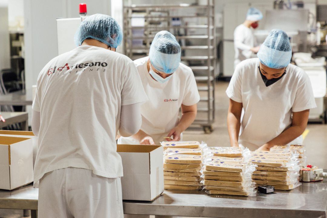 Varios trabajadores de &#039;El Artesano&#039; empaquetan los turrones durante una visita guiada por las instalaciones de la fábrica de turrones.