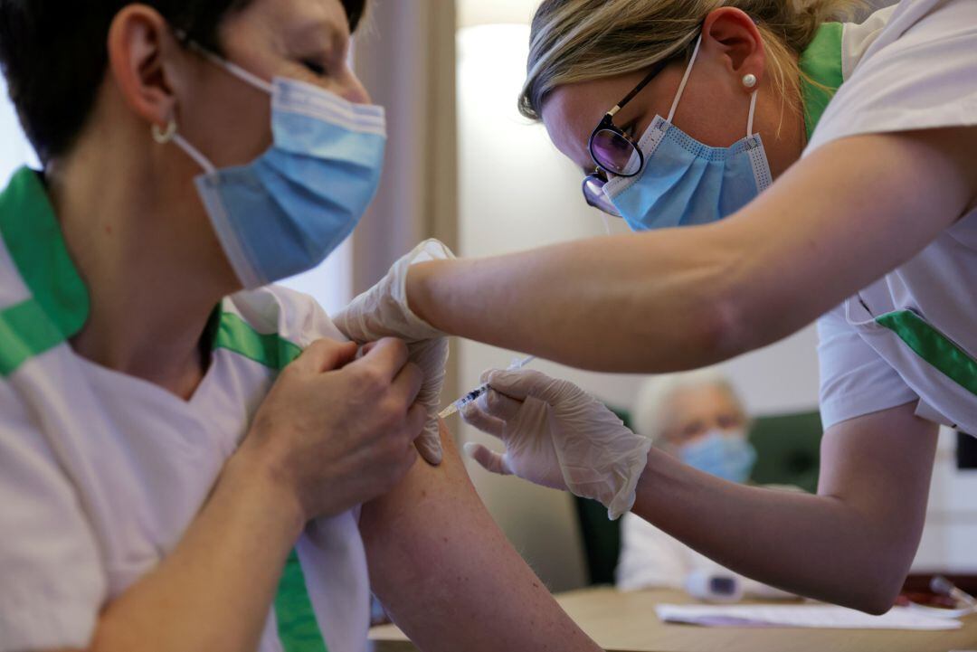 Una enfermera poniendo la vacuna a otra compañera en Francia