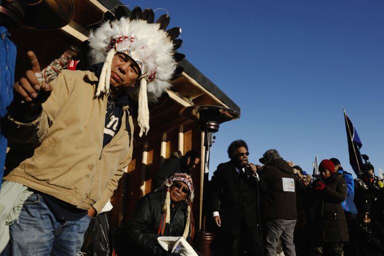 Oglala Sioux tribal elder Lance King (C) and Chief Arvol Looking Horse of Green Grass South Dakota, who is the spiritual leader of the Lakota, Dakota and Nakota Sioux Nations (C) listen as activist Dr. Cornel West speaks during an interfaith ceremony insi