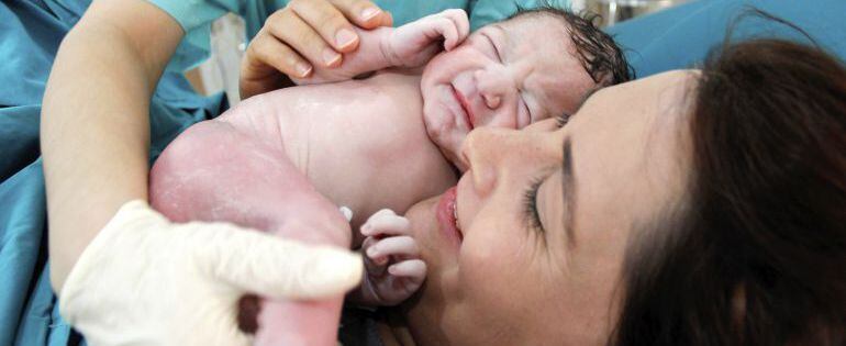 Bebe recien nacido en brazos  de su madre en el hospital