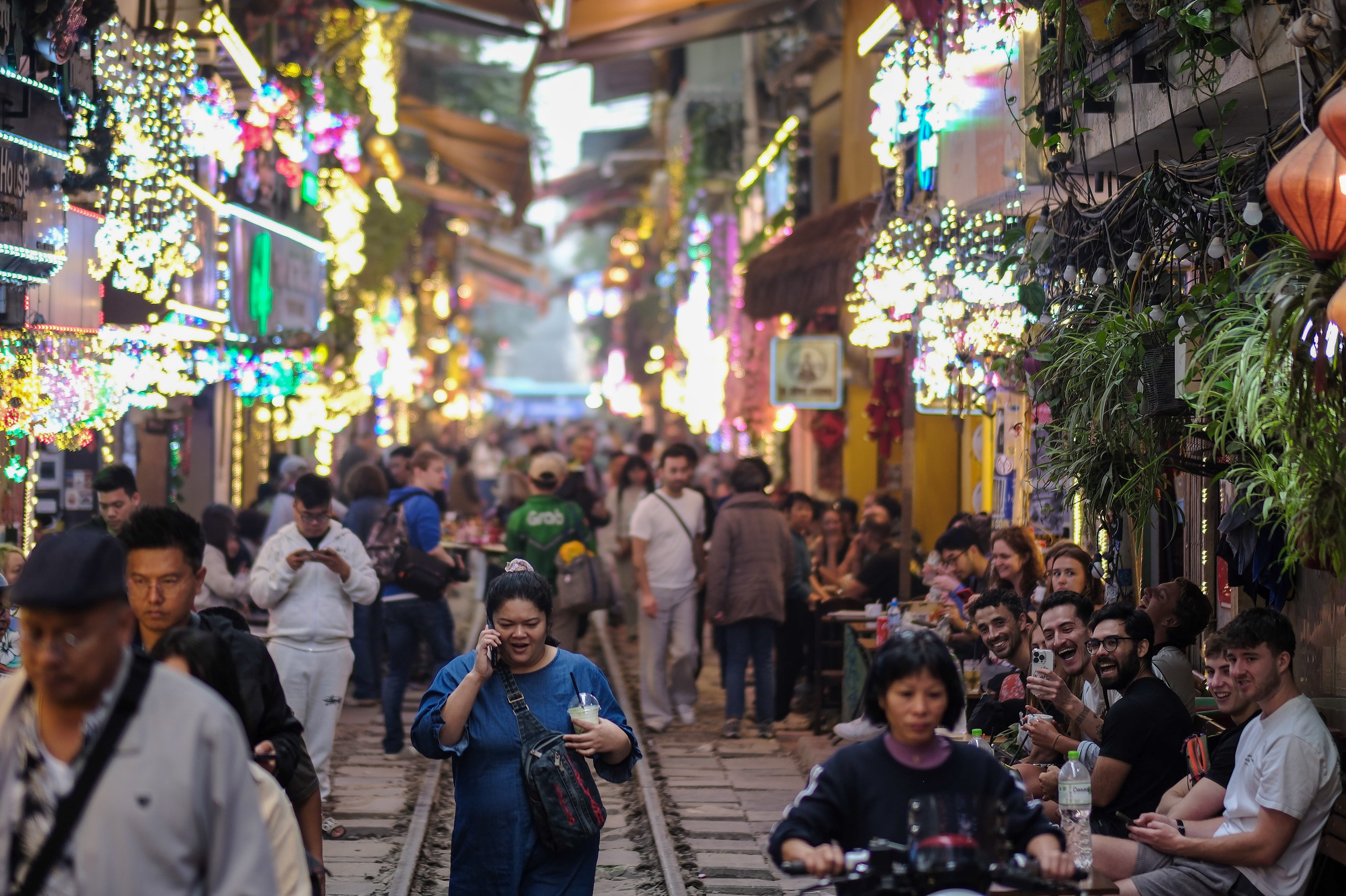 Turistas caminan por la famosa calle del tren de Hanoi.