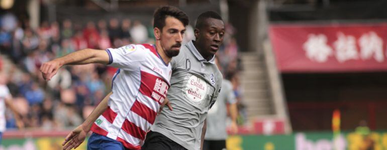 El centrocampista del Granada Isaac Cuencapersigue un balón junto al delantero colombiano del Deportivo Marlos Moreno.