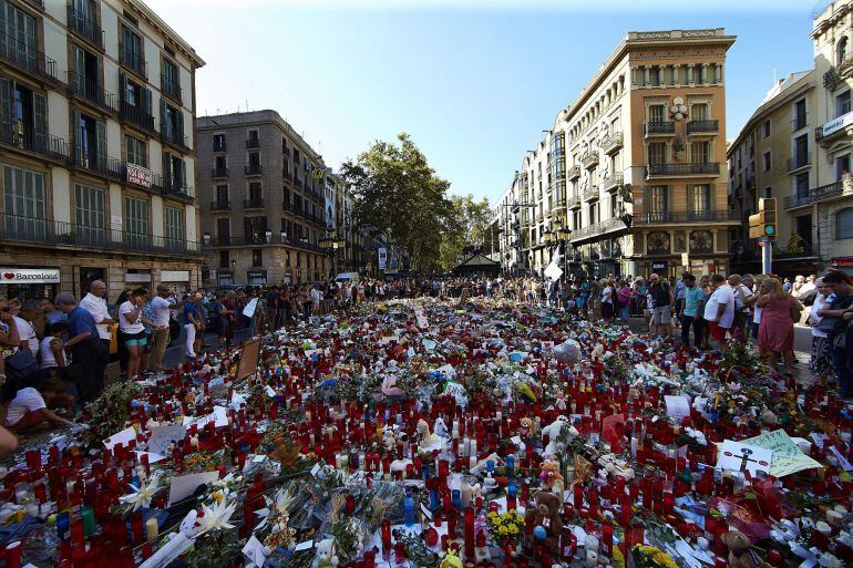 Cientos de personas se congregan en La Rambla de Barcelona, en el mosaico de Miró, lugar donde los ciudadanos depositan velas, flores y mensajes de apoyo y recuerdo a las víctimas del atentado del pasado jueves