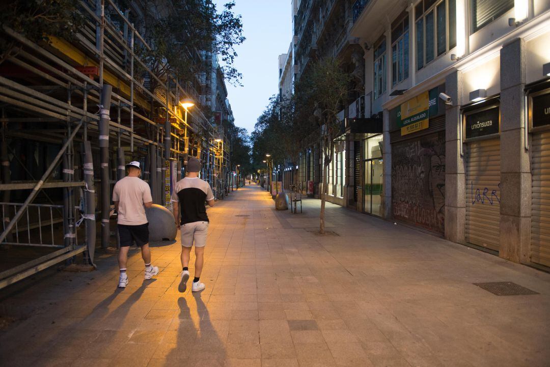 Dos jóvenes pasean por el centro de Madrid tras el anuncio del Estado de Alarma que realizó el presidente del Gobierno, Pedro Sánchez