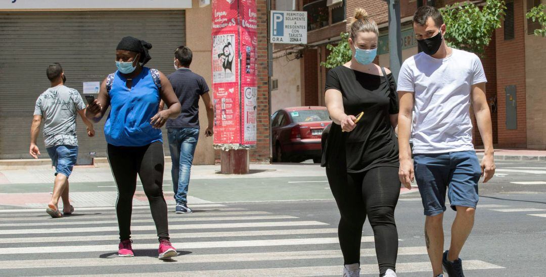 Varias personas con mascarilla cruzan un paso de peatones en la Avenida de Europa de Lorca