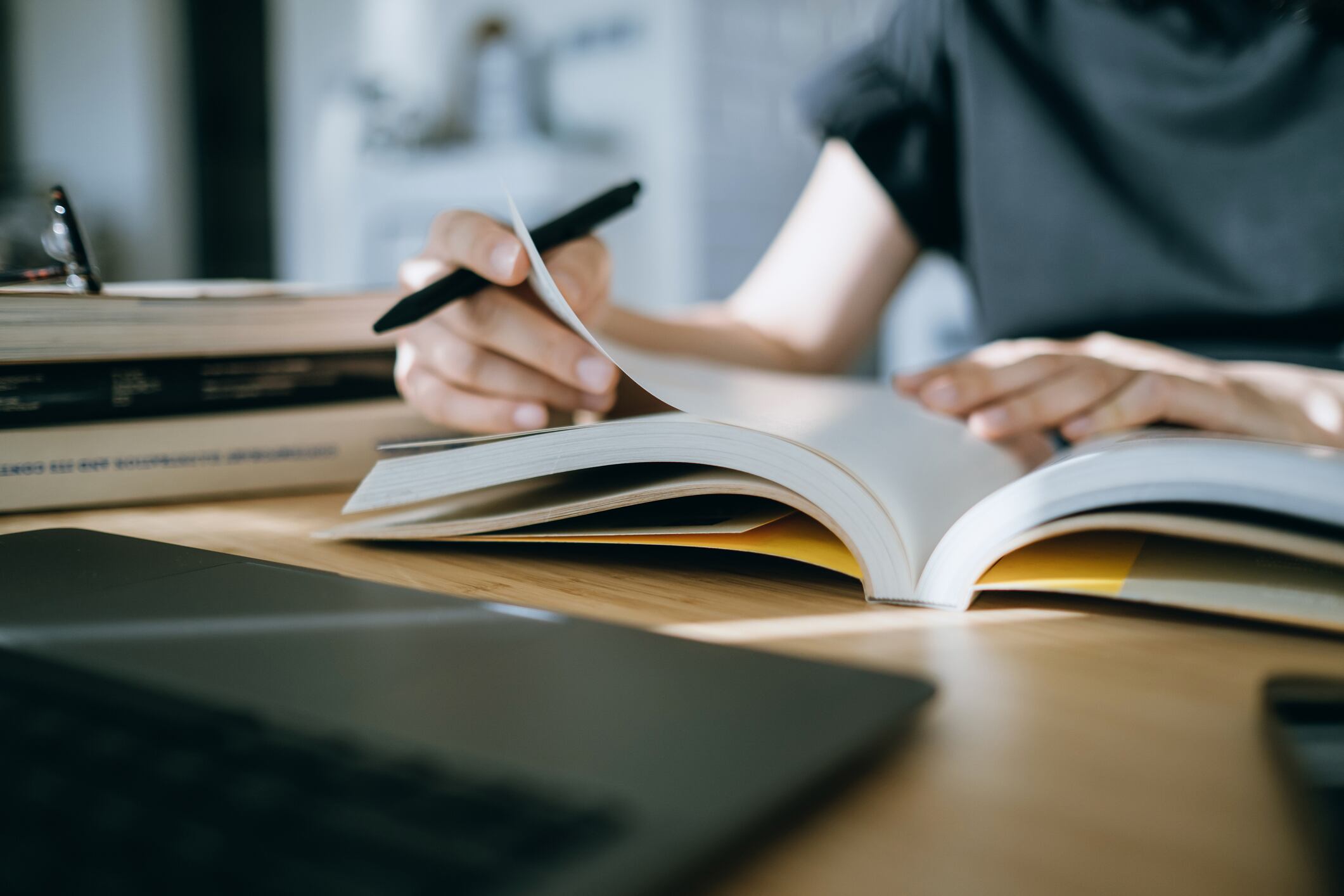 Una mujer, bolígrafo en mano, estudia con un libro de texto