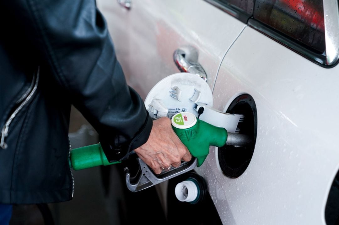 Una mujer pone gasolina a su vehículo en una gasolinera