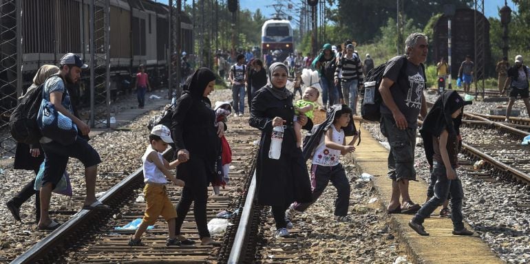 Inmigrantes esperan la llegada de un tren en dirección a la frontera con Serbia en la estación de Gevgelija en Macedonia.