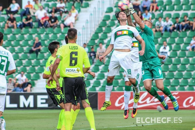 Pawel Kieszek atrapa el balón ante el central del Elche C.F. Pelegrín