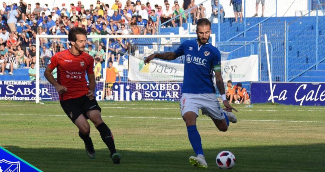 Josema golpea el balón ante la presión de un futbolista de La Nucía.