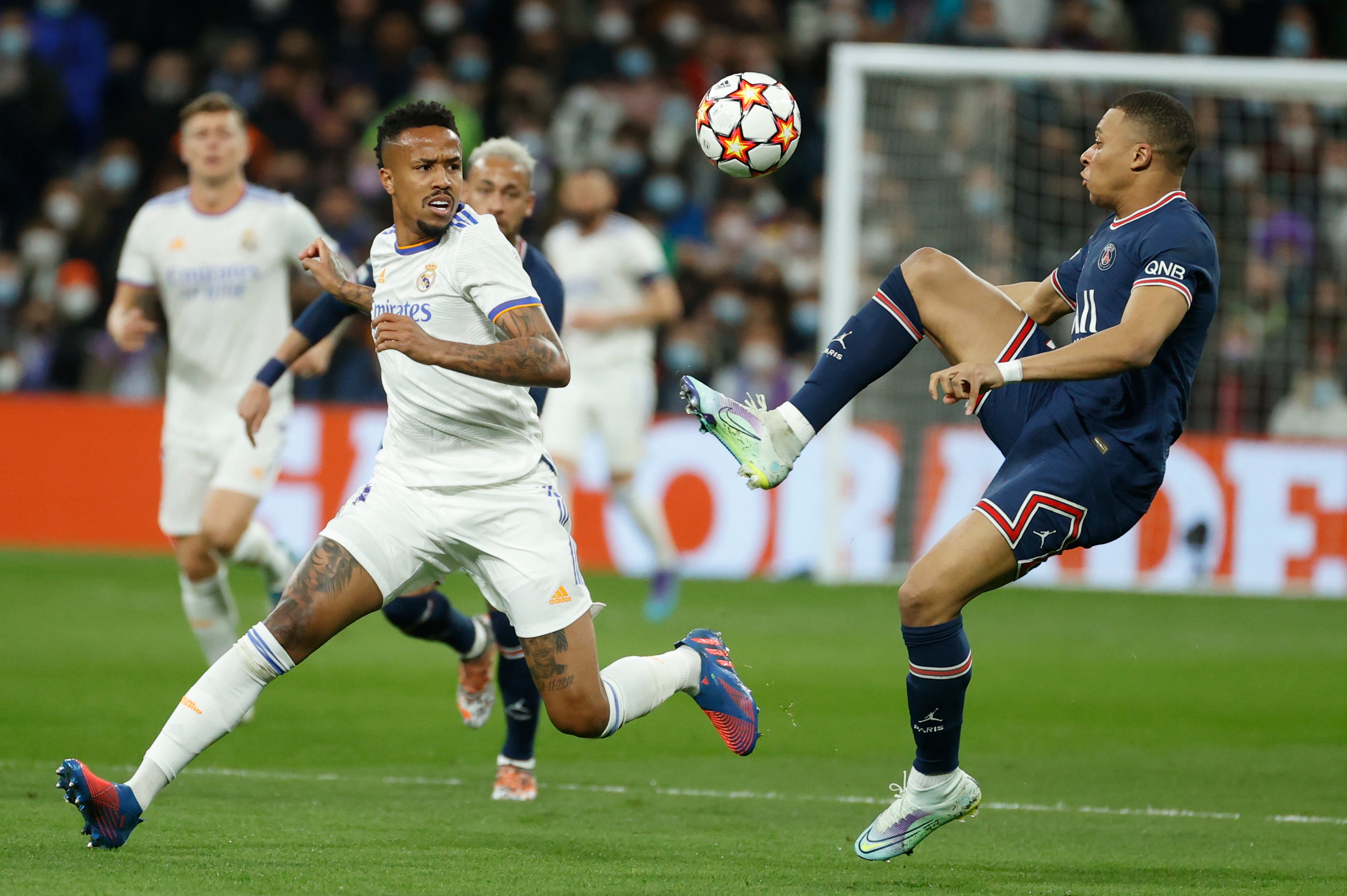 El delantero del PSG Kylian Mbappé con el balón junto al brasileño Éder Militao del Real Madrid, durante un partido de la Liga de Campeones