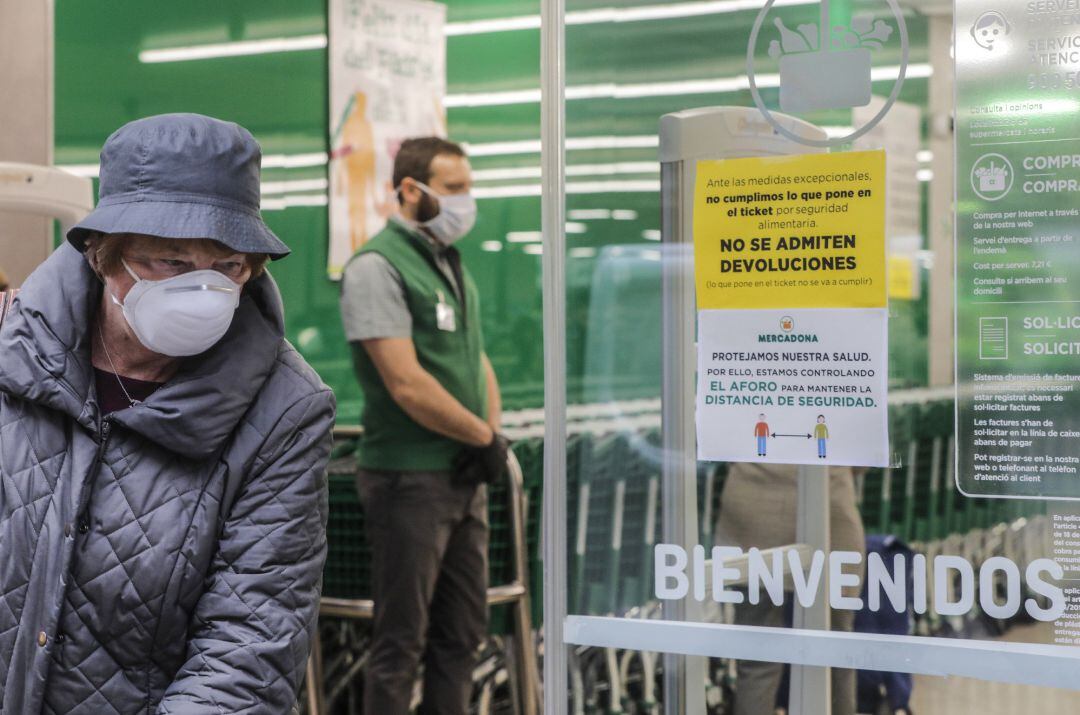 Una mujer con mascarilla a las puertas de un Mercadona.