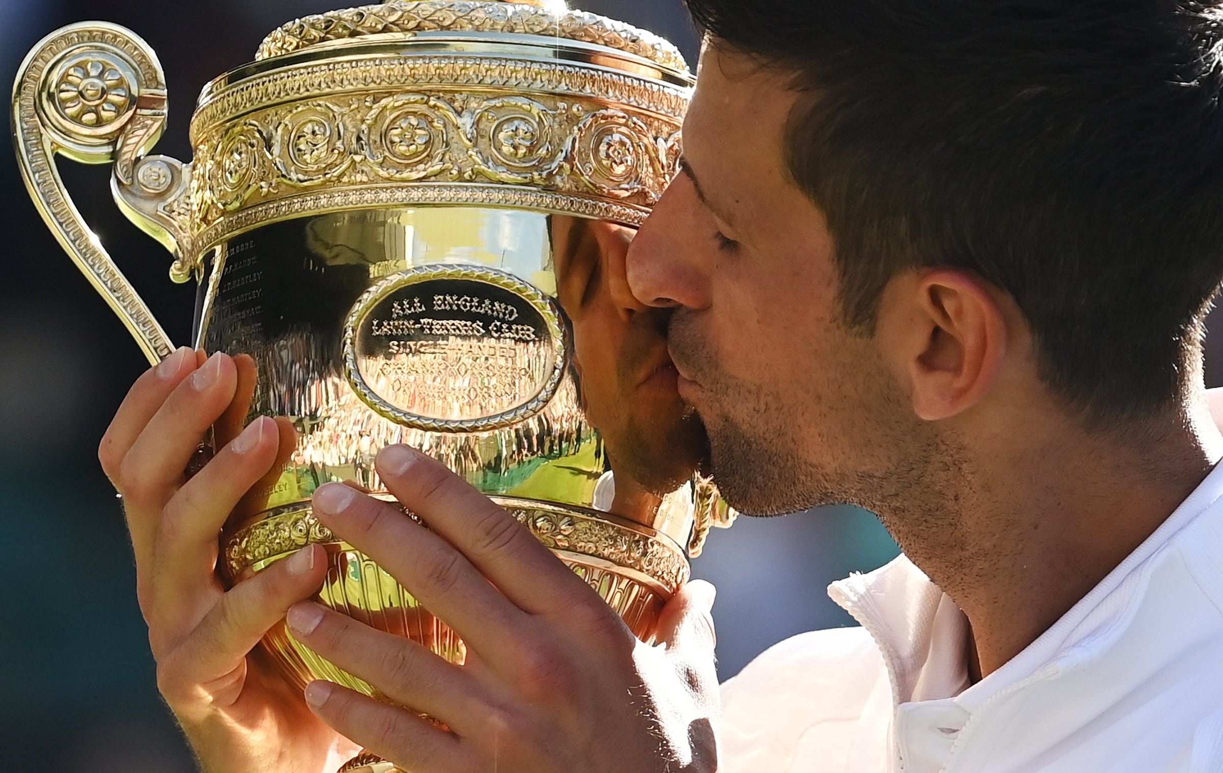 El serbio Novak Djokovic besa el trofeo después de ganar la final del torneo de Wimbledon ante el australiano Nick Kyrgios, hoy en Wimbledon, Reino Unido. EFE/NEIL HALL