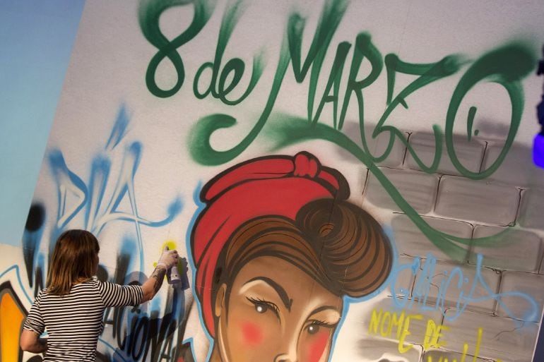 Una mujer pinta un graffiti por el 8 de marzo