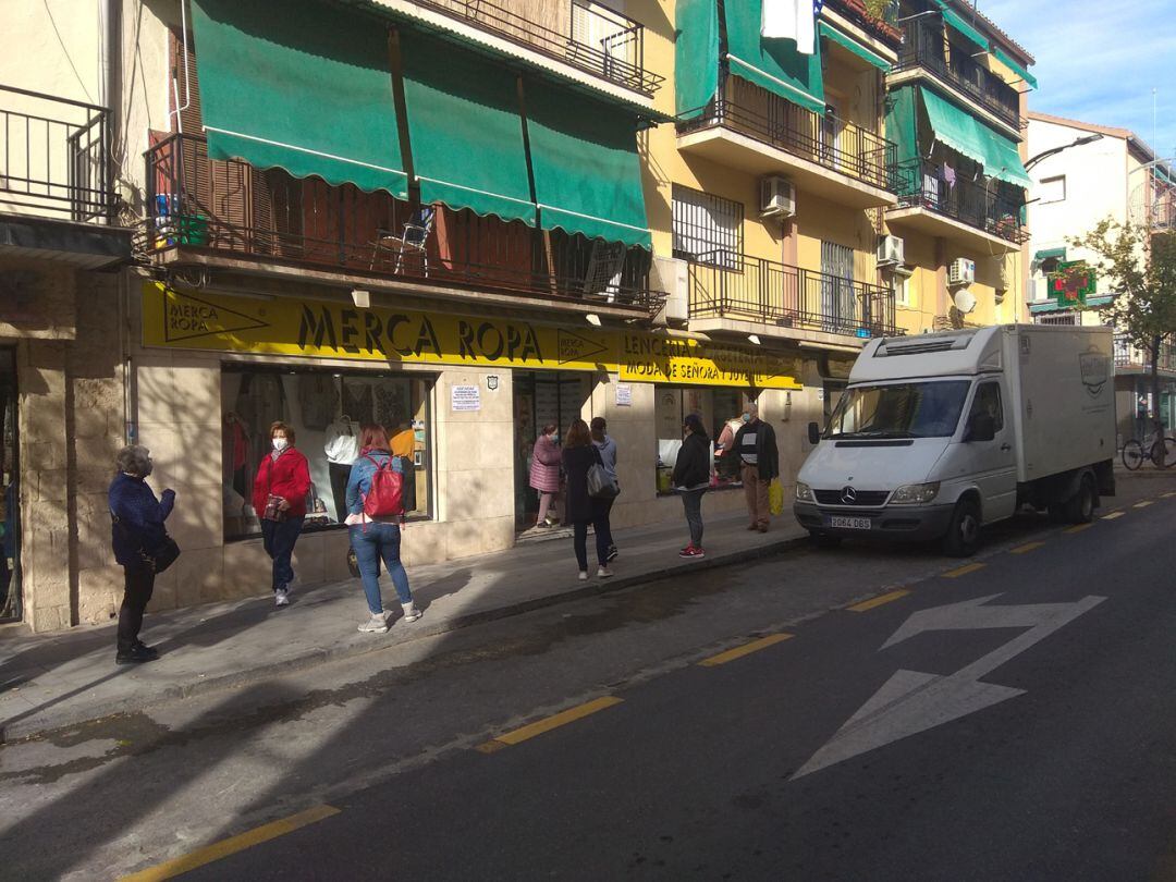 Clientes hacen cola para entrar en una tienda del barrio de La Chana de Granada, reabierta este 30 de noviembre tras 21 días de cierre por las medidas anti-covid en marcha