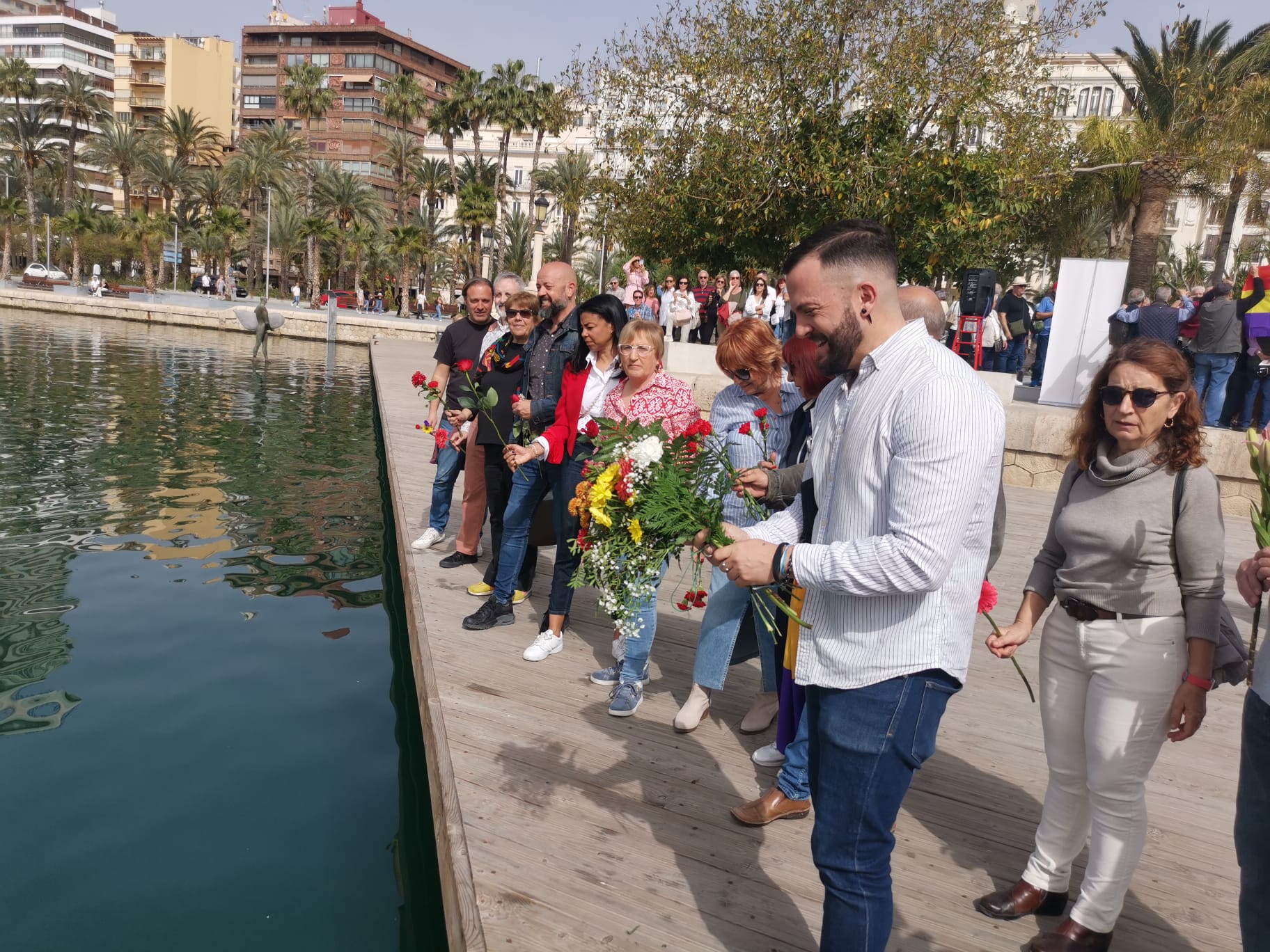 Los asistentes al acto lanzan rosas al agua en homenaje a los republicanos exiliados. Foto: Daniel Rodríguez