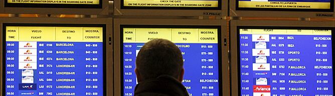 Una persona consulta en las pantallas los primeros vuelos de la mañana en el aeropuerto de Madrid-Barajas