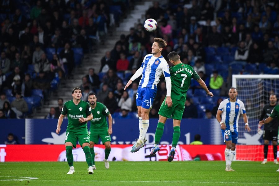 El jugador del Elche Óscar Plano disputa un balón aéreo con un rival