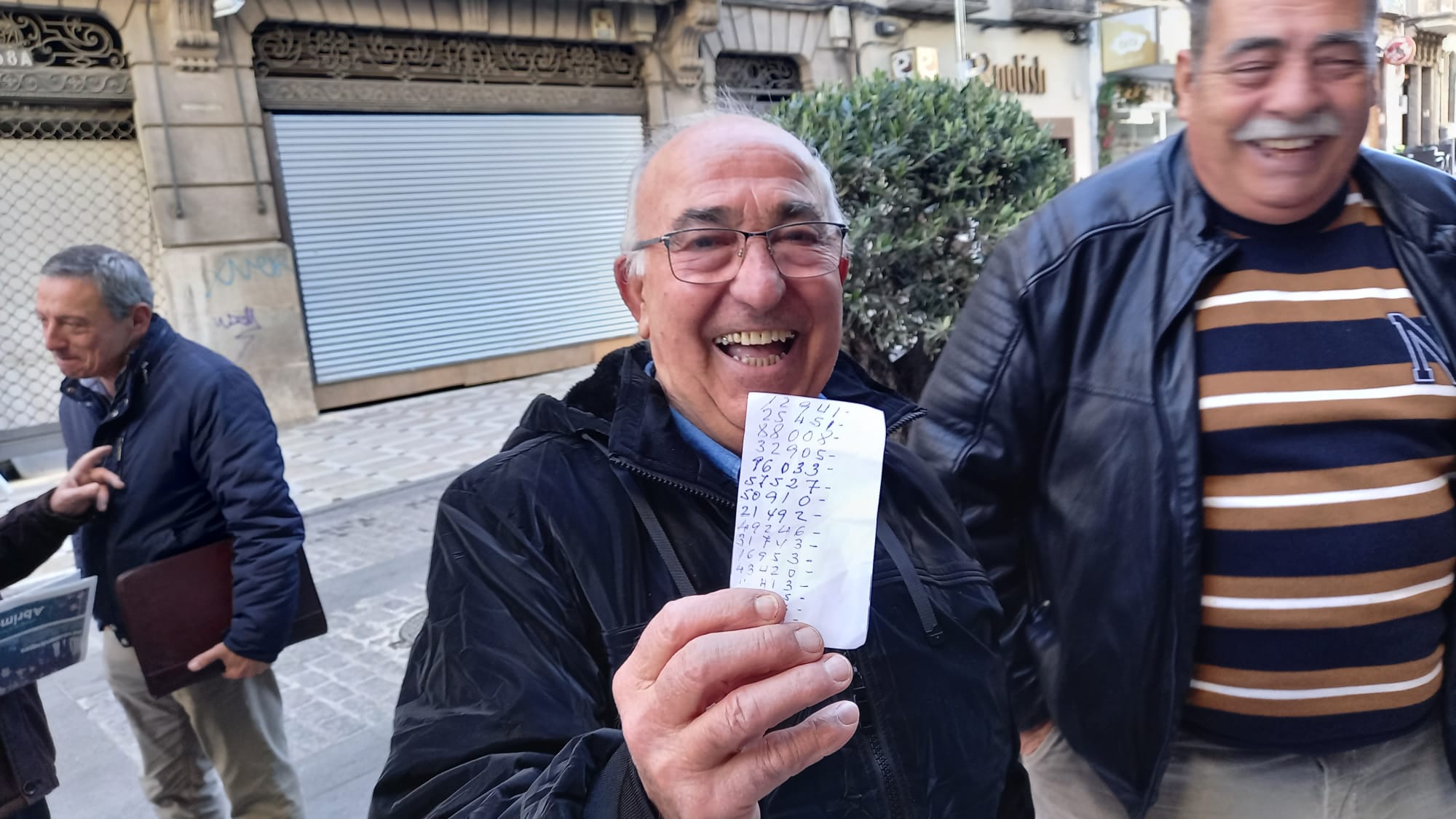 Uno de los agraciados con el Premio Gordo de la Lotería de Navidad de Jaén, mostrando sus números jugados