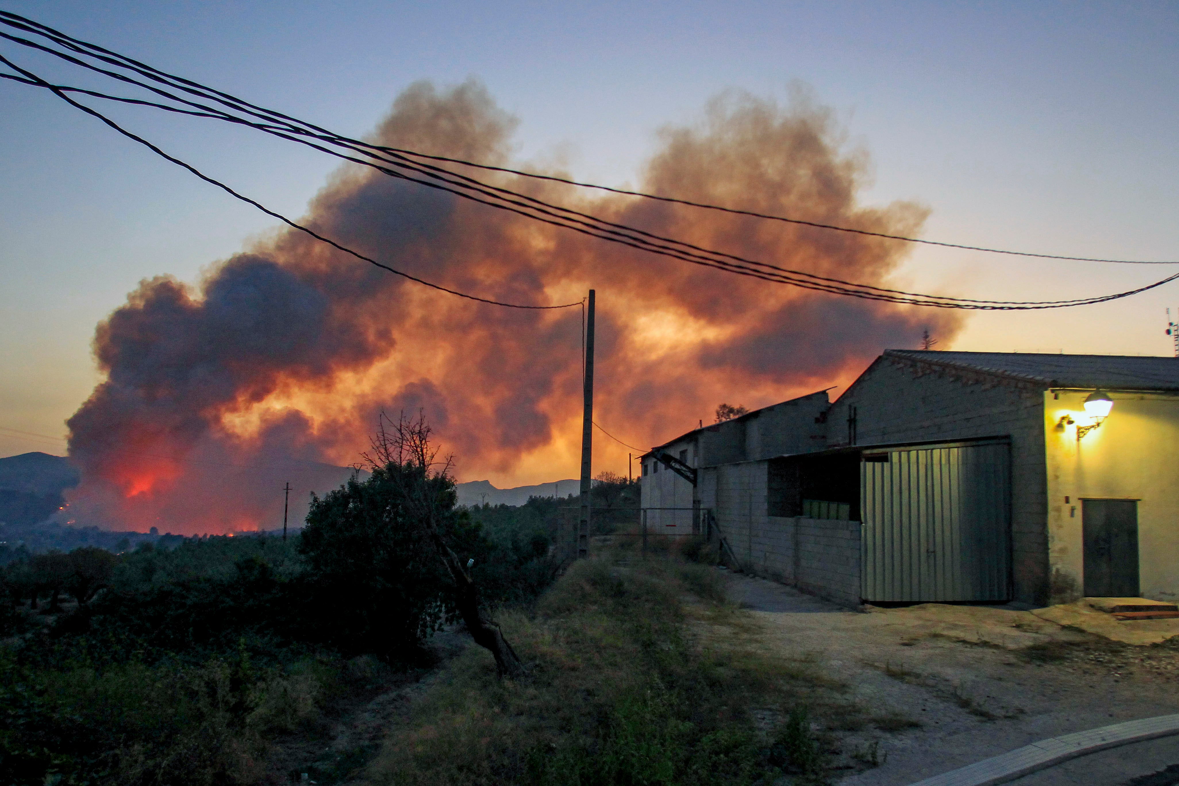 Incendio forestal de Benasau (Alicante), este martes. Las rachas de viento del suroeste, de entre 30 y 40 kilómetros por hora, una temperatura próxima a los 35 grados y la humedad relativa del aire dificultan las tareas contra el incendio forestal declarado a media tarde en Benasau, en el interior de la provincia de Alicante