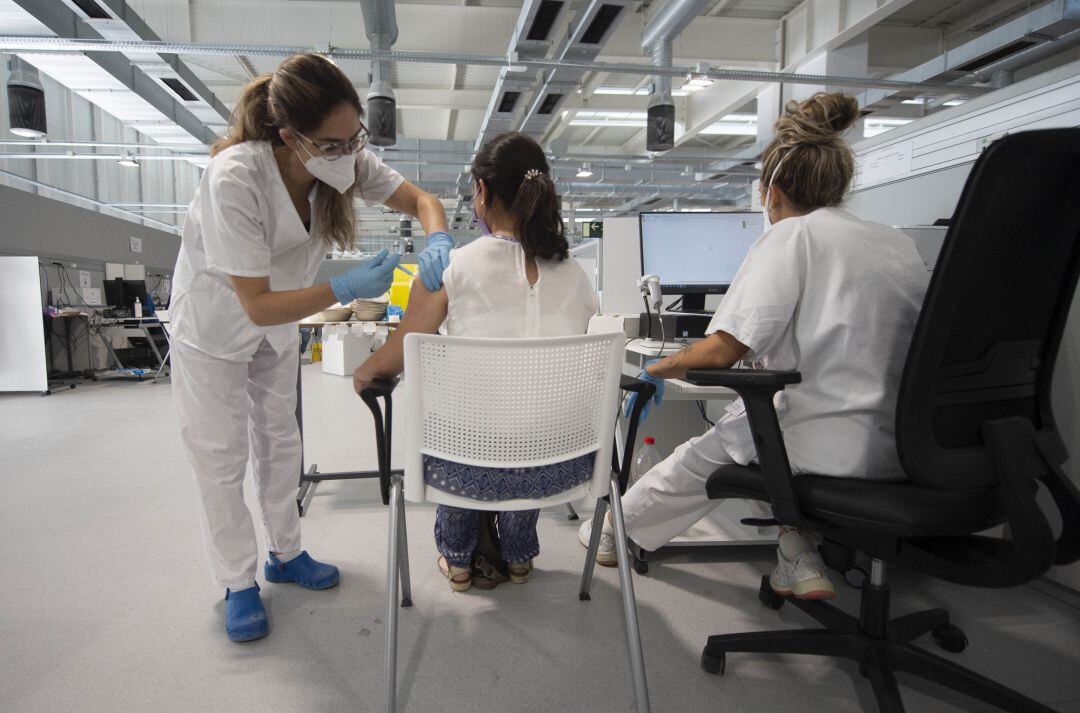 Una joven recibe la primera dosis de la vacuna Pfizer en el Hospital Zendal el día que comienza la vacunación a jóvenes madrileños a partir de 16 años