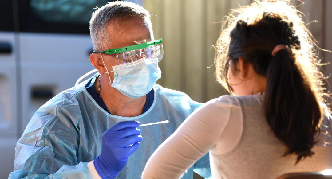 Un enfermero realiza el test de coronavirus a una paciente.