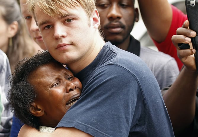 Un joven blanco abraza a una mujer negra tras la muerte de Mandela