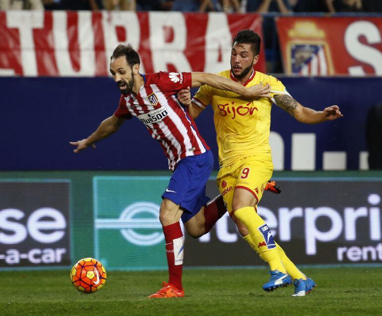 GRA313. MADRID, 08/11/2015.- El defensa del Atlético de Madrid Juanfran Torres (i) pelea un balón ante el delantero del Sporting de Gijón Miguel Angel Gerrero en partido de la undécima jornada de liga en Primera División que se disputa esta noche en el estadio Vicente Calderón.EFE/J.J. Guillen