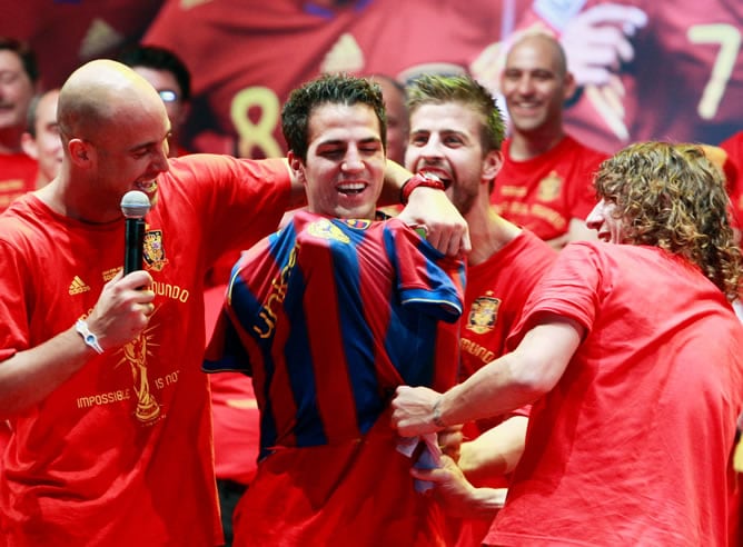 Reina, Cesc y Puyol durante la celebración del Mundial, mientras le colocan la camiseta del Barça al jugador del Arsenal