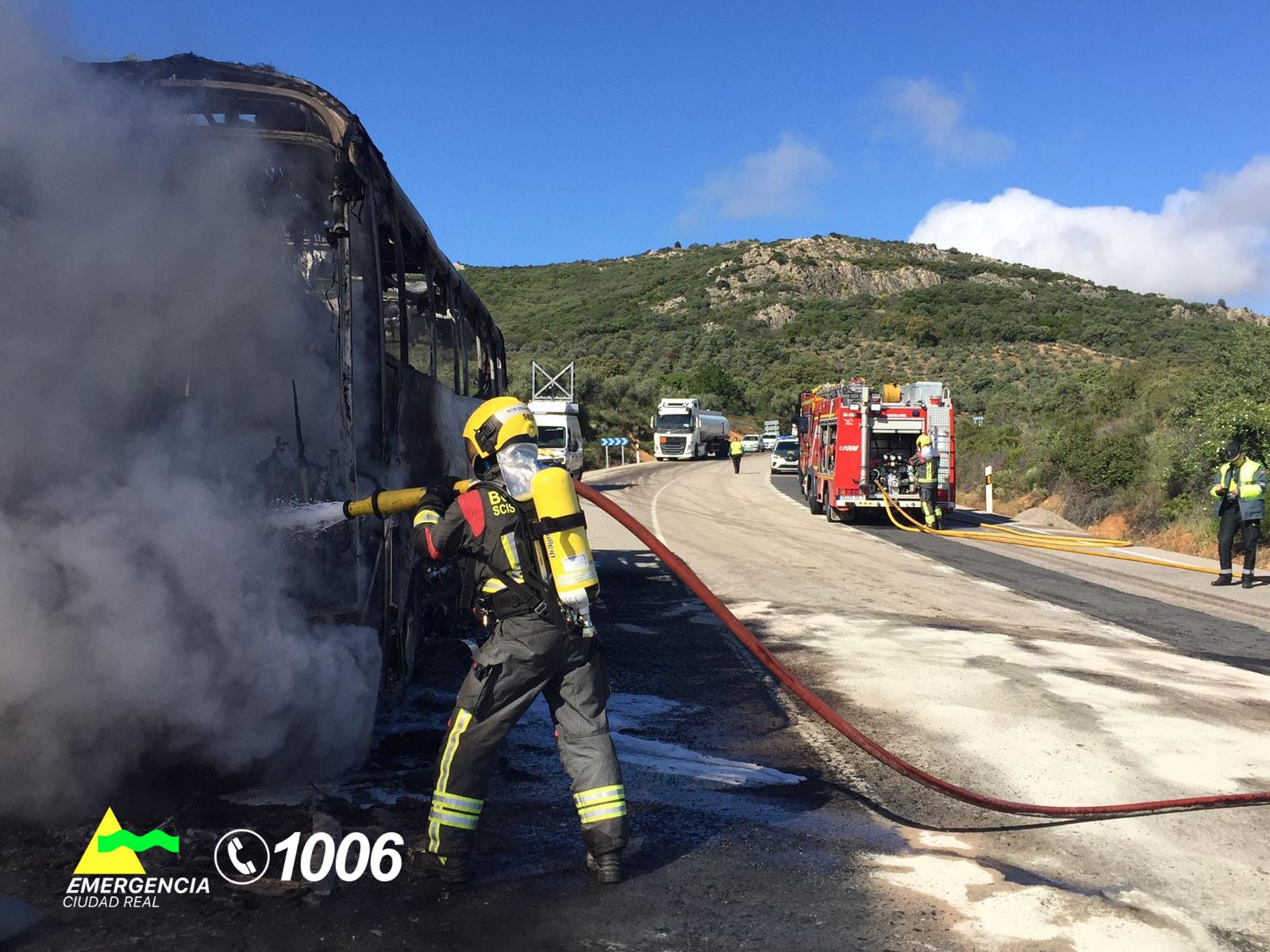 Bombero apagando el autobús en llamas