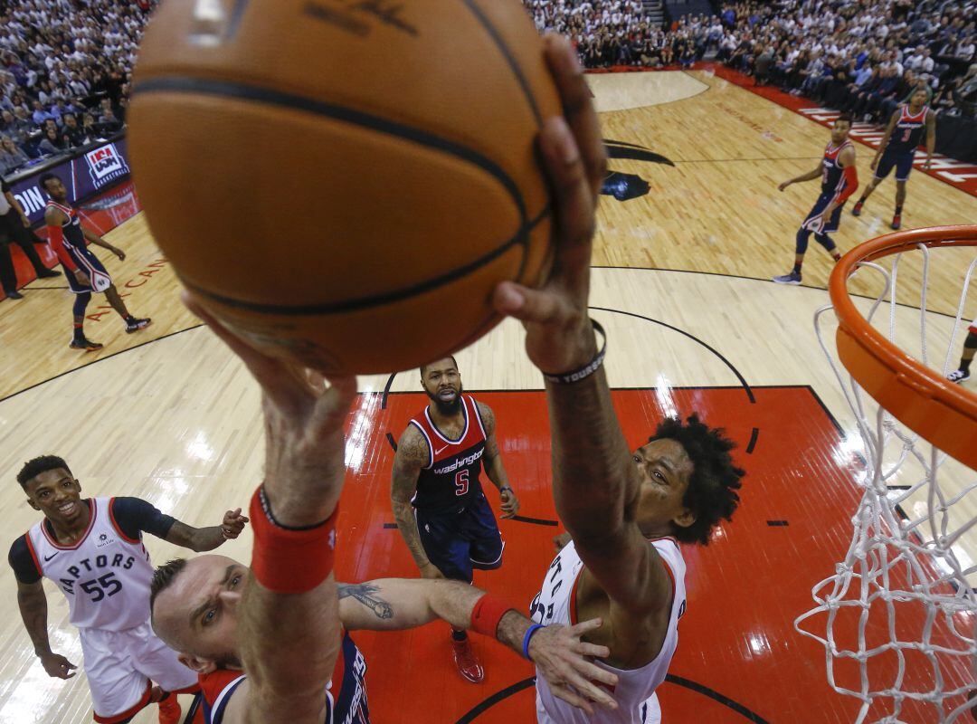 Lucas Nogueira (d) tapona a Marcin Gortat de los Wizards.