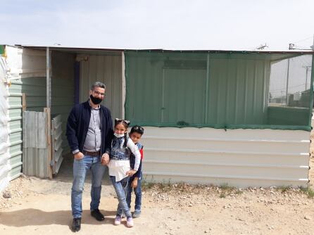 Hamed, junto a dos de sus hijos, frente a su taller