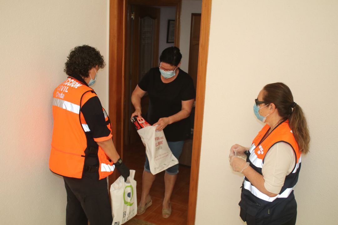 Miembros de Protección Civil reparten libros a domicilio